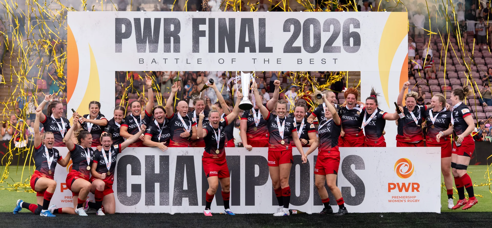 The winning team celebrating with the trophy at the PWR Final 2026, under a Champions board.