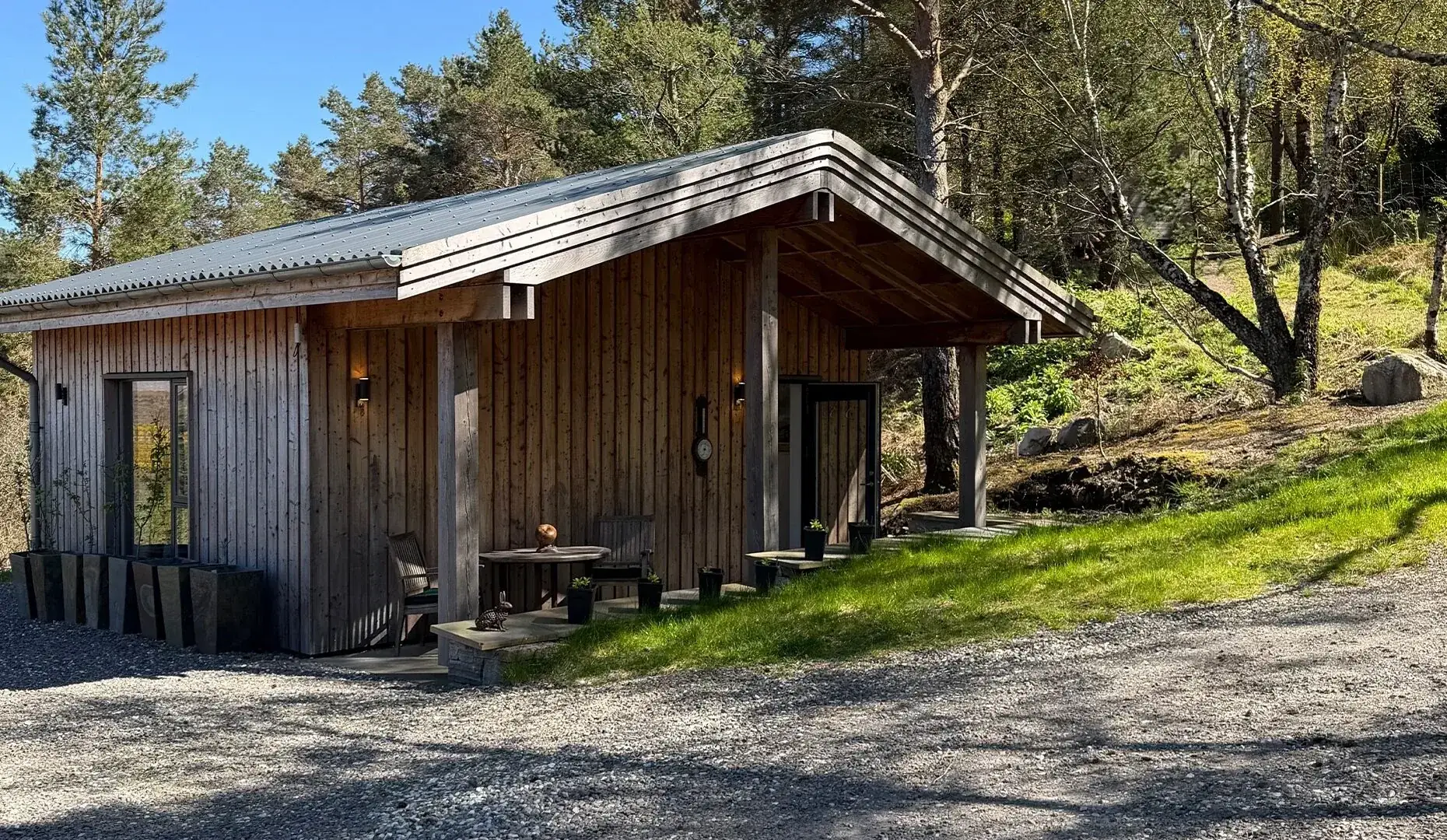 The Woodland Retreat, a timber cabin with a metal roof among pine trees.